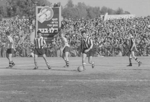 1958/59 - מחזור 7 - מכבי תל-אביב (0:1) - אריה רדלר עם הכדור. שבתאי זילברשטיין משמאל, ג'רי חלדי מימין. קרדיט - ארכיון הסרטים הישראלי