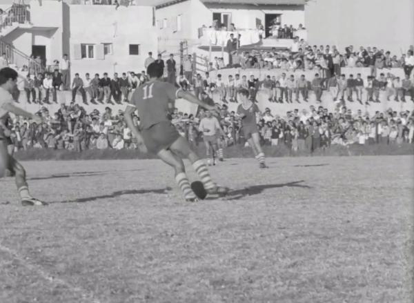 שחקני הפועל פ"ת ובני יהודה על רקע יציעי המגרש בשכונת התקווה. קרדיט - ארכיון הסרטים הישראלי
