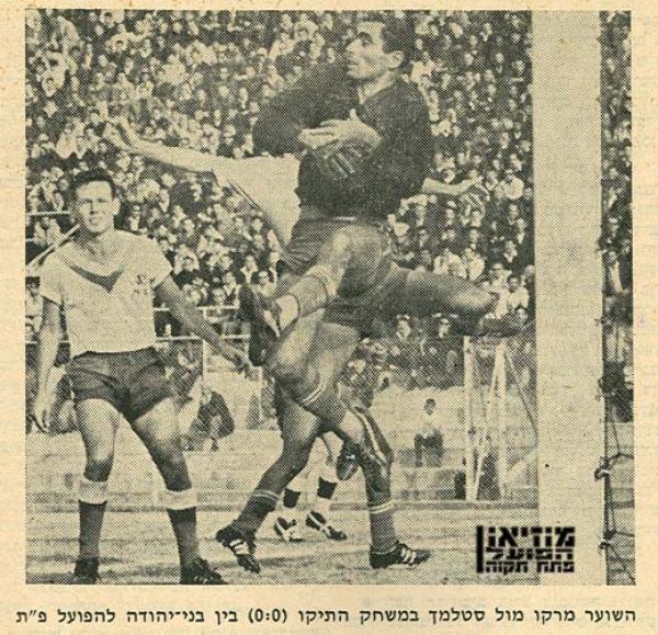 שוער בני יהודה מרקו עבוד קולט את הכדור, נחום סטלמך משקיף מקרוב