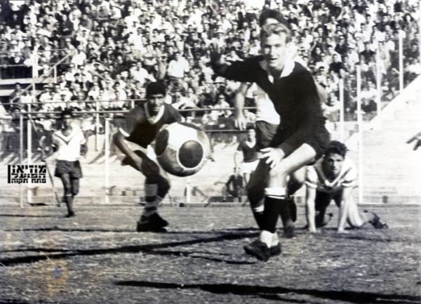 1964/65 - מחזור 6 - שמשון תל-אביב (1:2) - שוער הפועל, מיקי שינפלד, מביט בכדור בדרכו החוצה. שמוליק רוזנטל על הקרקע מימין, זאב שמור ברקע משמאל ומשה רומנו משמשון במרכז.