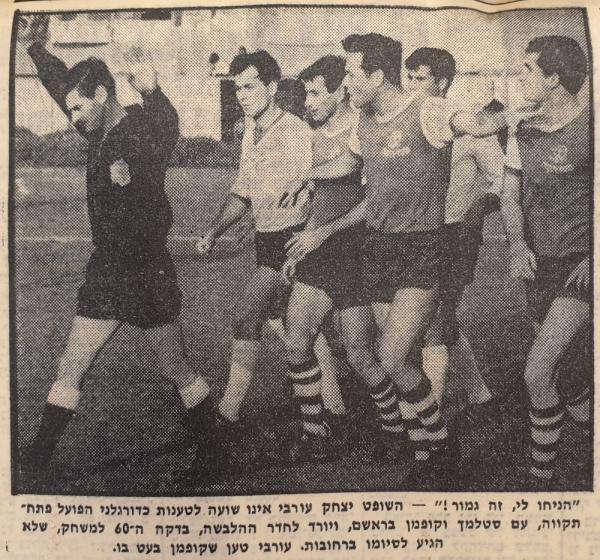 שחקני הפועל פ"ת, בראשות נחום סטלמך ובועז קופמן, מנסים לשכנע את השופט יצחק עורבי שלא להפסיק את המשחק מול שעריים