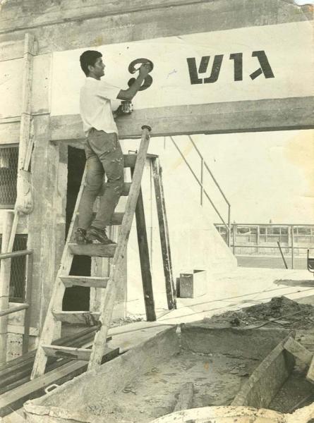 1967 - חלוץ הקבוצה, שאול חייק, מסיים לצבוע את הכיתוב מעל אחד השערים ביציע המזרחי של האיצטדיון החדש.