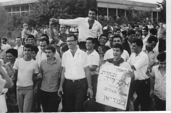 התהלוכה שליוותה את אלקנה שמן בחזרה מהשבי למחנה יהודה. צילום: באדיבות ד"ר מעבי, שאוחז בשלט בחזית