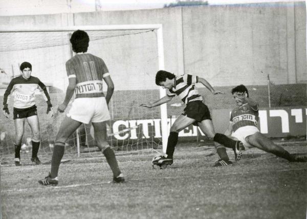 1984/85 - מחזור 15 - מכבי תל-אביב (2:0) - ניר אלון מנסה לבלום את מיקי בן-שטרית, רוני ג'רבי מתכונן בשער.