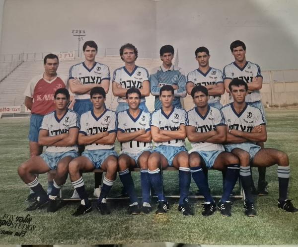 הפועל פתח תקוה מודל 1988/89, תמונה קבוצתית. עומדים, מימין: ניר לוין, דוד לוי, רפי כהן, איתן בודניוק, ניר אלון, אברם גרנט (מאמן). יושבים: בני קוזושווילי, נועם קייסי, גיא לוי, אלי מחפוד, עוז אליה, מני בסון
