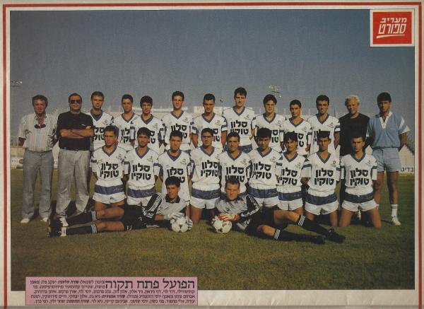 הפועל פ"ת מודל 1989/90 תמונה קבוצתית. למעלה, מימין - יעקב פלג (מאמן כושר), שטיינר קרוגסטד (פיזיותרפיסט), בני קוזושווילי, דוד לוי, דני ניראון, ניר אלון, אלון חזן, גבע מרקוס, יוסי לוי, אורן פרקש, איתן בודניוק, אברם גרנט (מאמן), יוסי רוזנצווייג (מנהל). למטה - גיא גת, אלון יצחקי, חיים סירוטקין, רפעת עודה, אלי מחפוד, מני בסון, יוסי שושני, נעם קייסי, גיא לוי. על הדשא - שחר ילין, רפי כהן