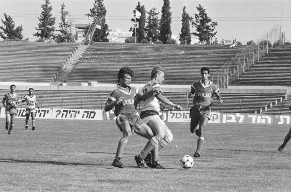 1989/90 - מחזור 31 - מכבי חיפה (1:2) - סטאסיס ברנאוסקאס עם הכדור, פביאן גרימברג מאחוריו ויוסי צרפתי מימין. צילום: אריה קנפר