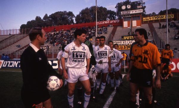 1991/92 - טוטו - חצי גמר - בני יהודה (1:0) - שחקני הפועל פ"ת ובני יהודה בעלייה לבלומפילד בחצי גמר גביע הטוטו. ניר לוין מוביל את שיירת שחקני הפועל פ"ת, מאחוריו השוער רפי כהן (מוסתר), בהג'ת עודה, אלון חזן, חיים סירוטקין ומוראד אבו קישאק. מוטי איווניר בראש שחקני בני יהודה. צילום - בועז לניר
