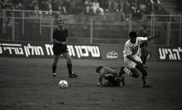 מני בסון עם הכדור, מאחור השופט סבי אלנקווה