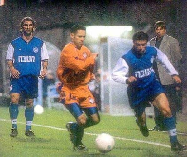 בורימיר פרקוביץ' ואודי כבודי נאבקים על הכדור, אלישע לוי (מאמן ראשל"צ, מימין) ואילן בוארון משקיפים מאחור.