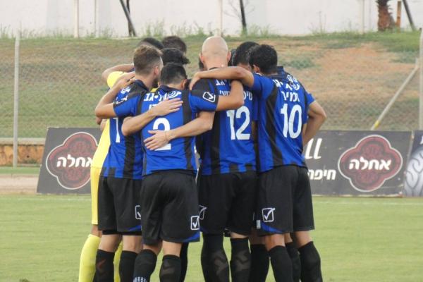 שחקני הפועל פ"ת מתגבשים לפני תחילת המשחק. לא עזר