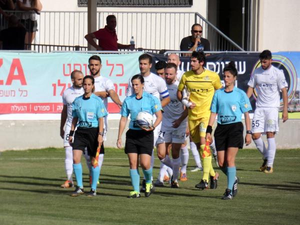 שחקני הפועל פ"ת עולים למגרש ברמלה בליווי צוות השופטות