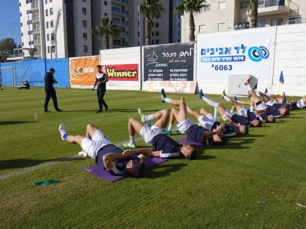 שחקני הפועל פ"ת מתחממים בפתיחת המשחק